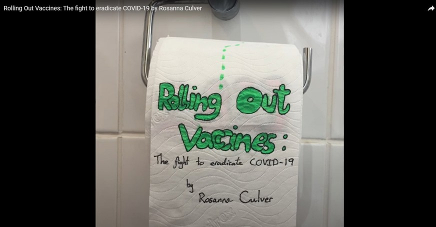 Still image from the video showing toilet roll with the words 'Rolling out vaccines' in green