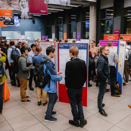 Main image of female speaker in front of a wooden podium and Biochemical Society banner backdrop. Secondary image is of group of attendees networking among poster boards.