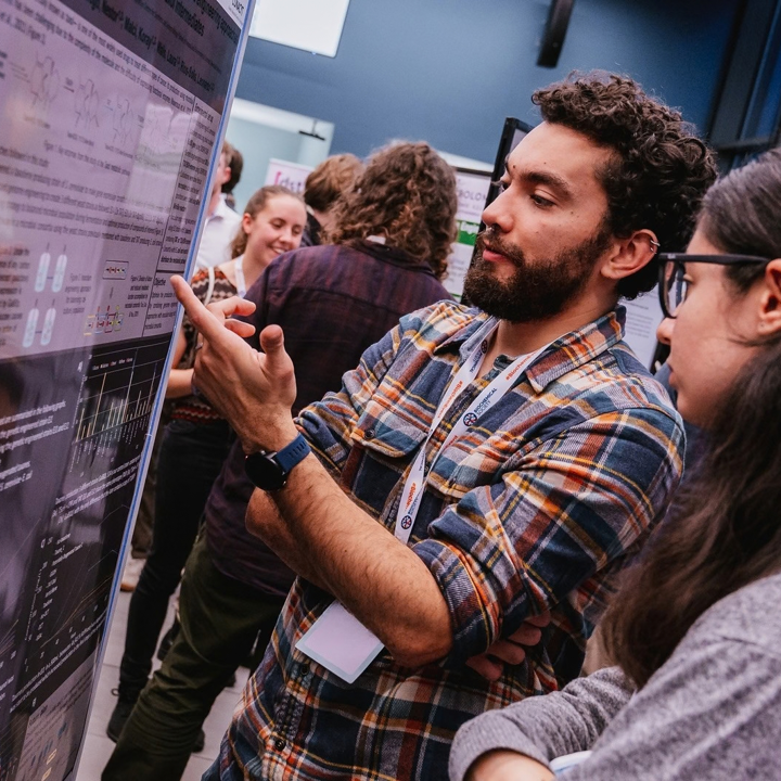 Main image is of two students discussing a scientific poster. Secondary image is of attendees networking during a poster session.
