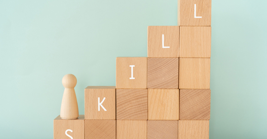 Wooden blocks in a stair shape spelling out 'skill'