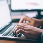 Data scientist typing on a laptop
