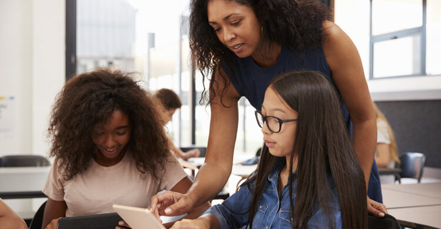 Female teacher mentoring two students