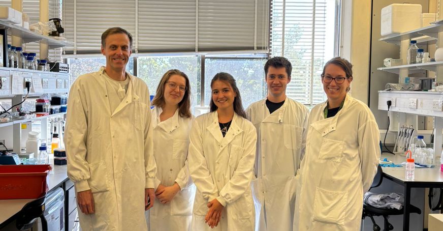 Altea Ramon Guillena with 4 members of the Ben Miller lab, standing in white lab coats.