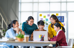 Group of students and employees working around a laptop