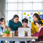 Group of students and employees working around a laptop