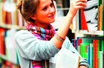 person in a library removing books from the shelf