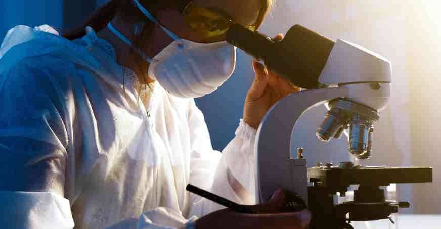 Woman looking into a microscope