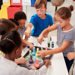 Young children and an adult carrying out a colourful, scientific activity