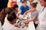 Young children and an adult carrying out a colourful, scientific activity