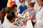 Group of children getting involved with an experiment with an educator