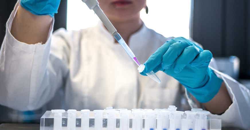 Scientist pipetting coloured liquid